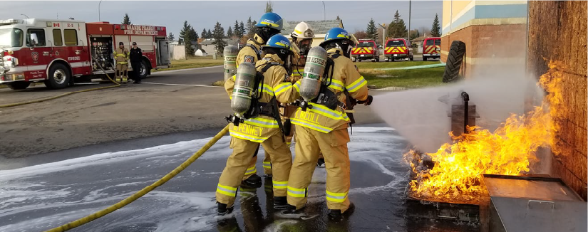 Firefighters in Yellow suits fighting a small fire