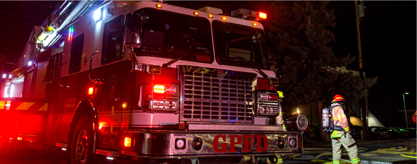 Firefighter standing in front of a fire truck at a scene