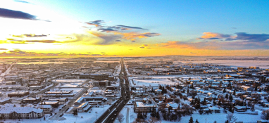 Ariel landscape of residential and business communities of Grande Prairie in the winter while the sunsets