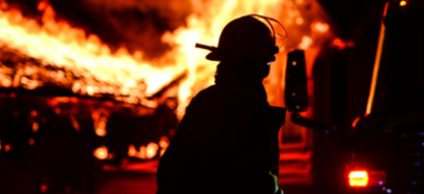 Firefighter standing back from flames