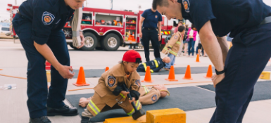 Two firefighter teaching a small child 