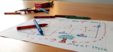 Crayons and piece of paper with an escape route drawn out