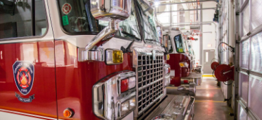 Red fire trucks parked in a garage